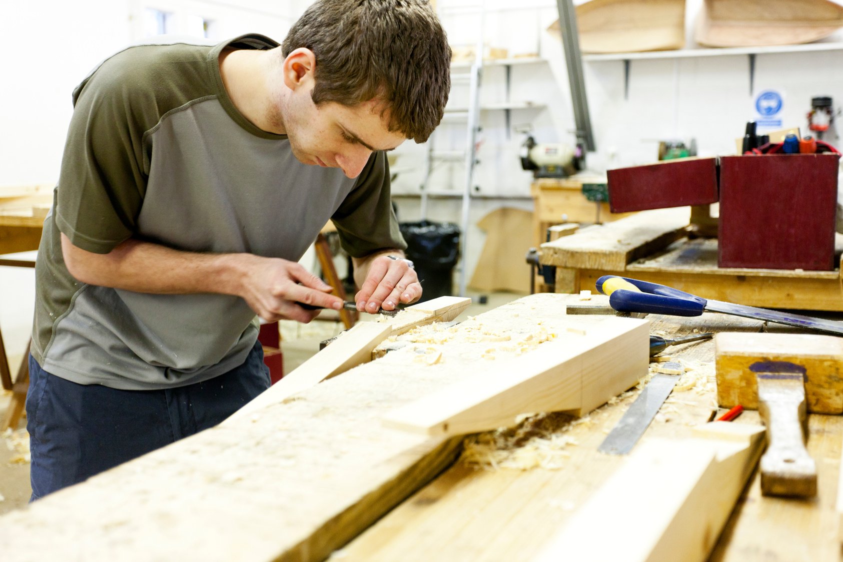 Boat builder working with a chisel